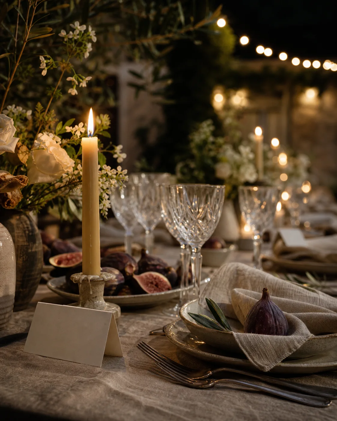 Figs, crystal glassware and candles on a formal table
